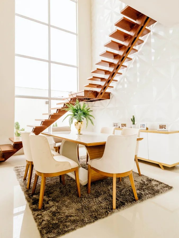 Modern dining room with elegant chandelier and colorful furniture designed by Ago Construction